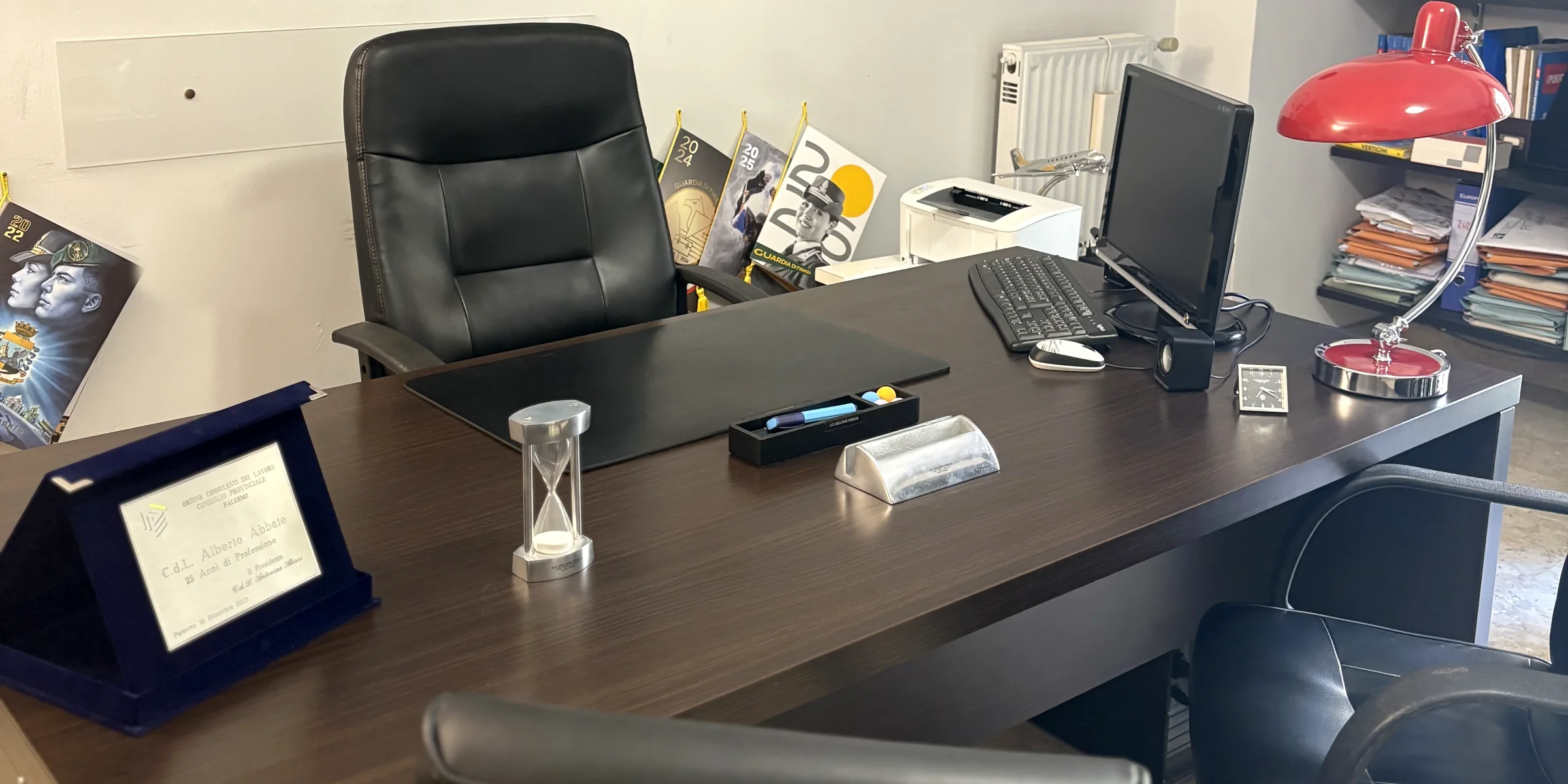 La scrivania reale dello Studio Abbate a Palermo, con la targa dei 25 anni di professione in basso a sinistra